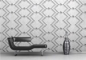 Textured geometric decorative concrete wall panel behind a lounge chair and vase