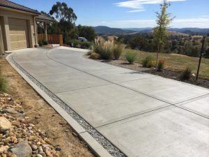 Long concrete driveway curving through a rural hillside property