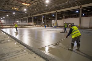 Large concrete warehouse floor being poured and screeded
